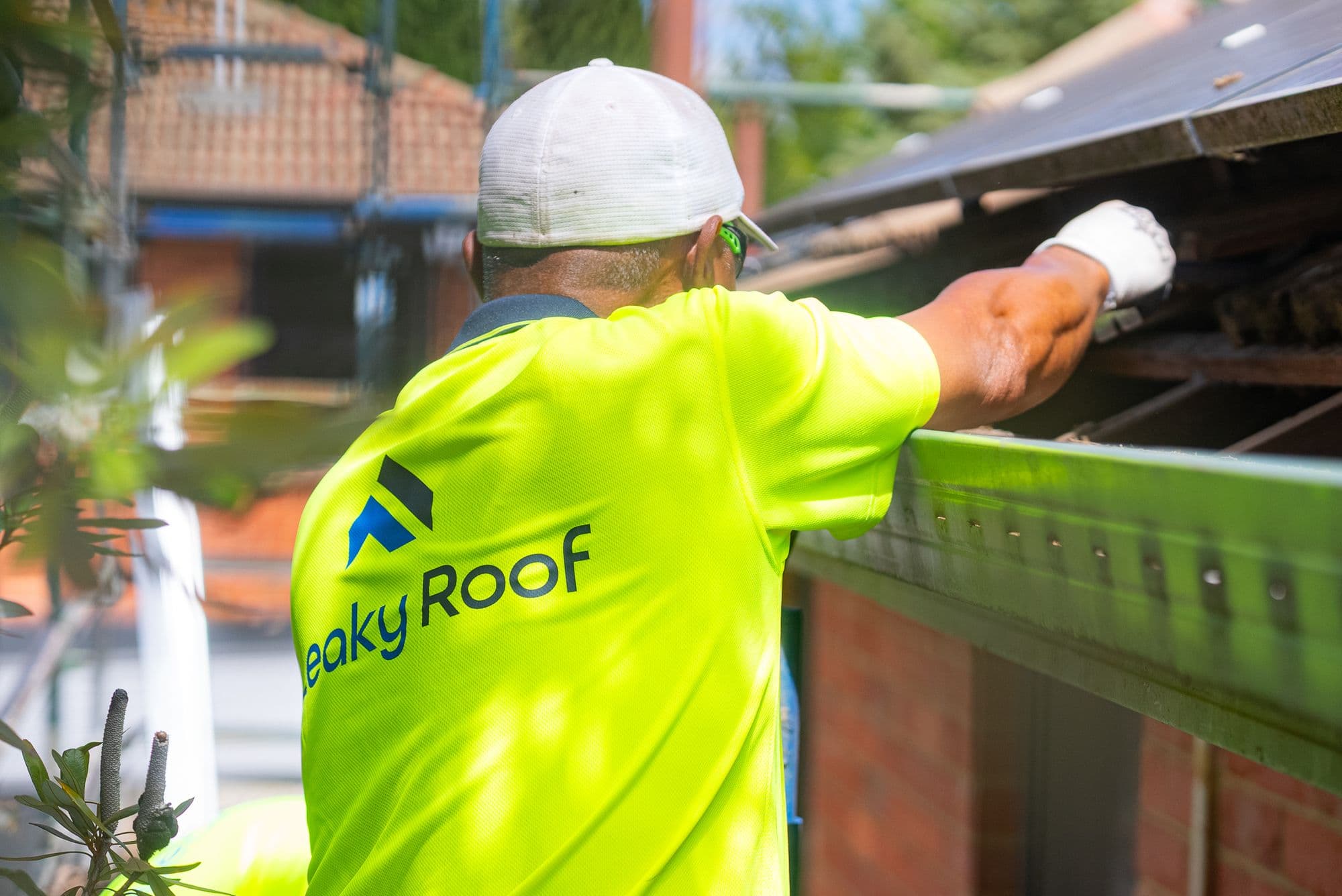 A Leaky Roof roofer working along the edge of a tiled roof